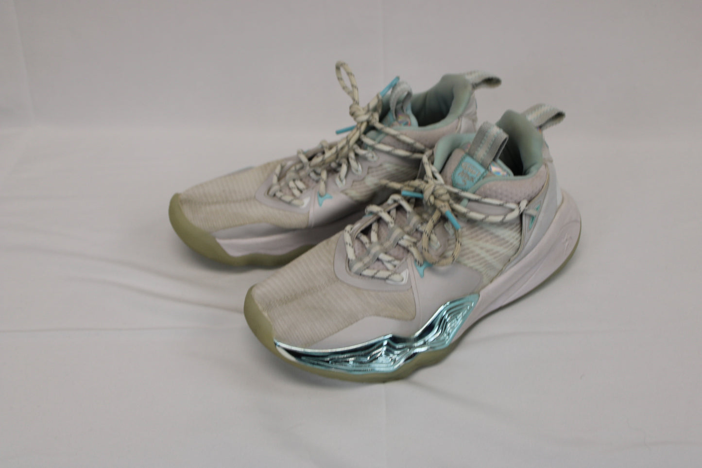 And 1 low top basketball shoe, white/teal metallic, Youth 7